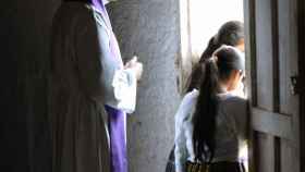 Un párroco observa desde atrás a unas niñas