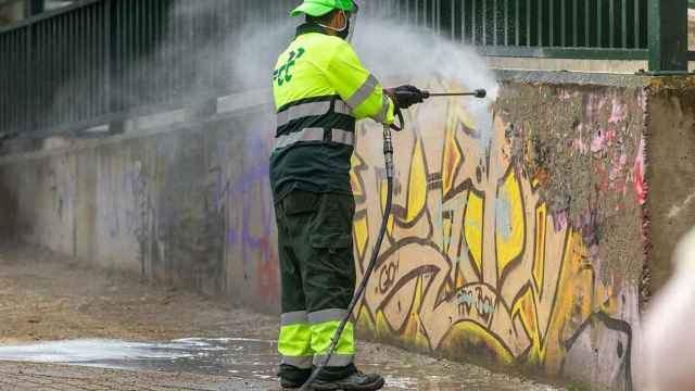 Un operario limpiando un grafiti en Madrid.