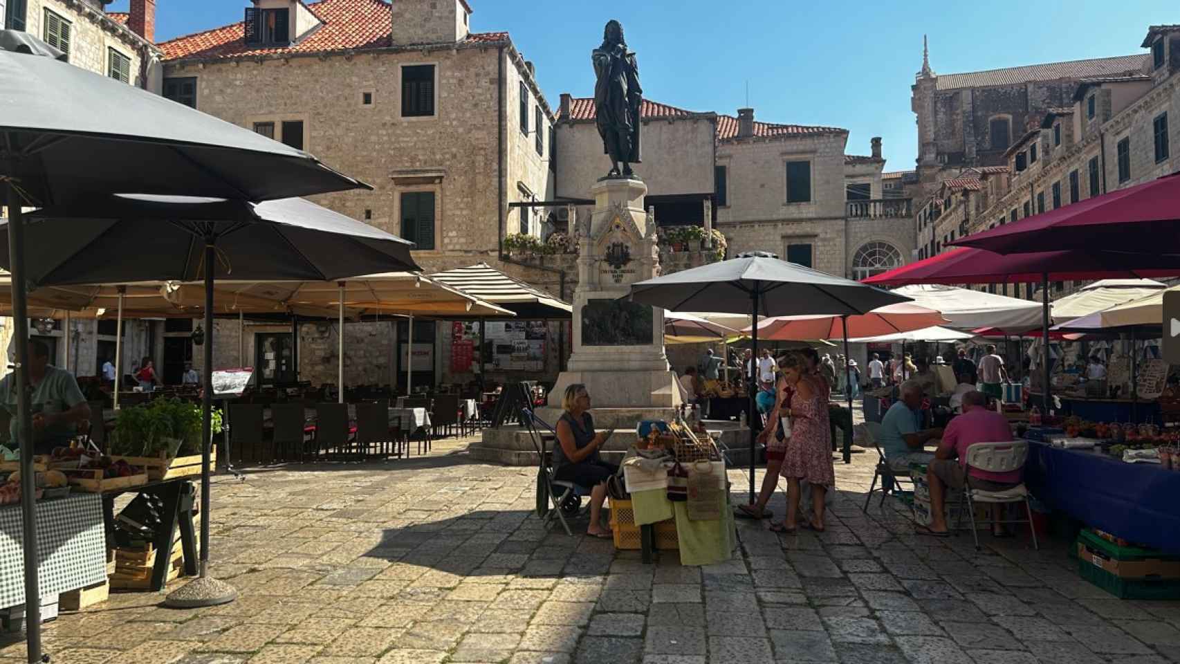 Un mercado local y terrazas de conviven en una de las plazuelas del casco histórico de Dubrovnik