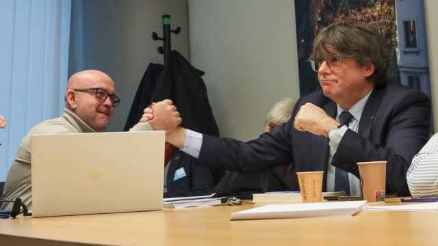 Carles Puigdemont bromea con su abogado, Gonzalo Boye, durante un acto celebrado el pasado mes de febrero en el Parlamento europeo.