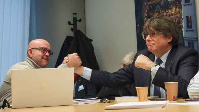 Carles Puigdemont bromea con su abogado, Gonzalo Boye, durante un acto celebrado el pasado mes de febrero en el Parlamento Europeo.