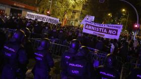 Decenas de personas con banderas y pancartas durante una concentración en contra de la amnistía, frente a la sede del PSOE en la calle Ferraz.