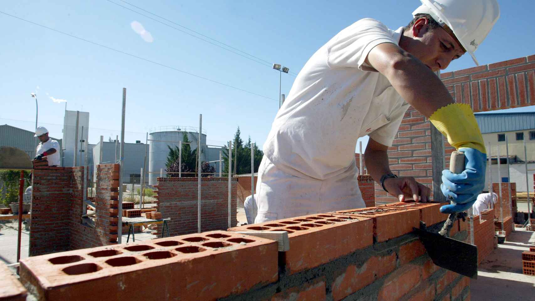 Un trabajador coloca unos ladrillos en una obra