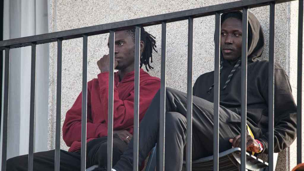 Dos migrantes descansan en el Hotel Baixamar.