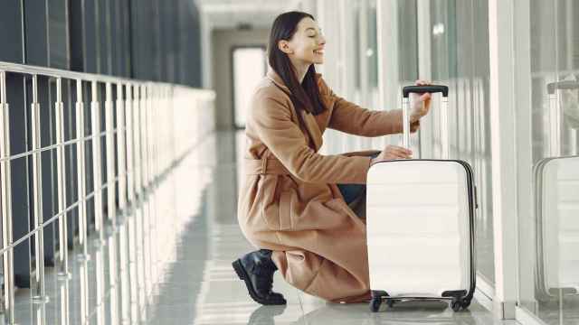 Imagen de una mujer con su maleta en el aeropuerto
