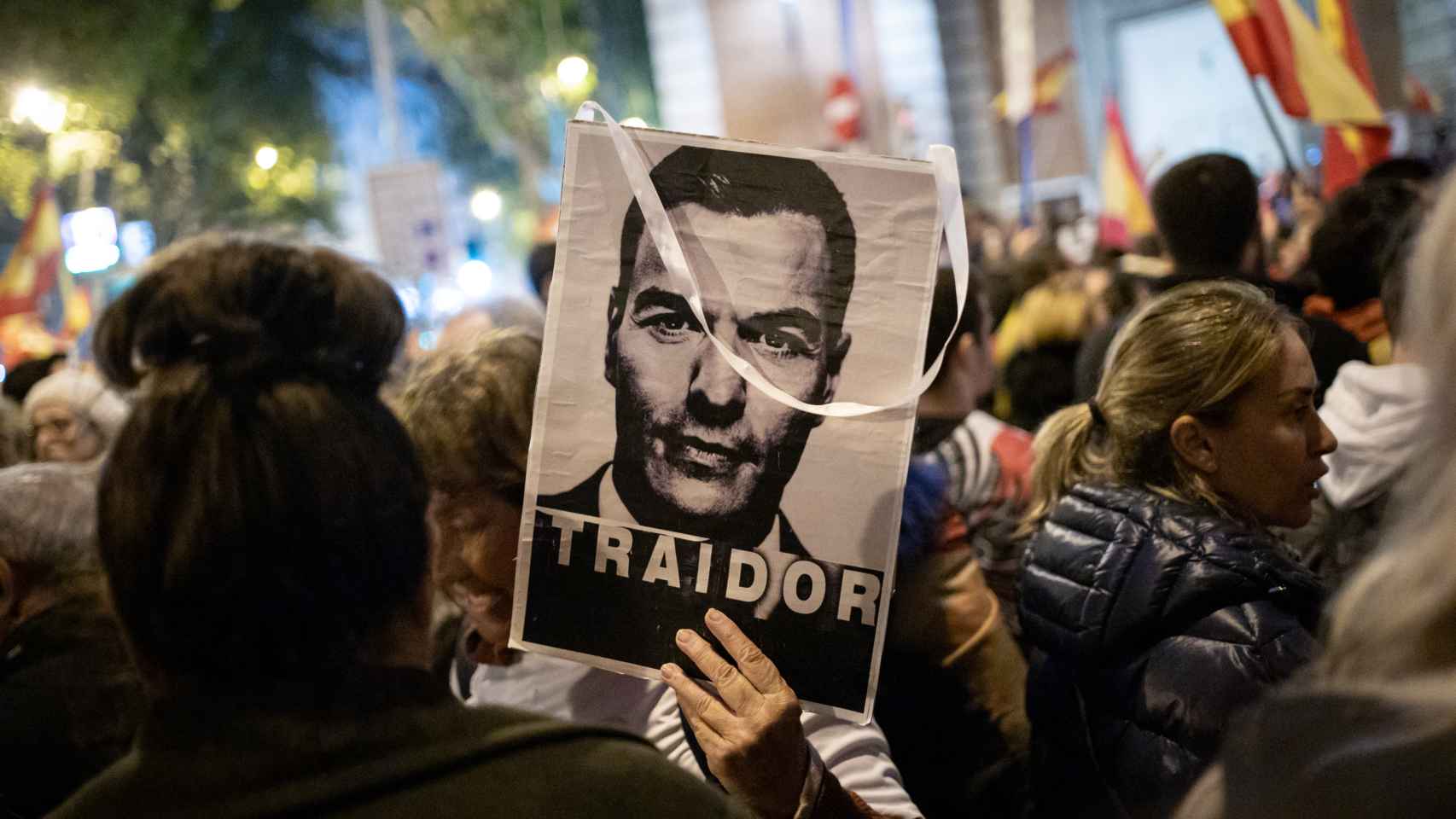 Un manifestante sujeta un retrato de Pedro Sánchez sobre el lema Traidor, este viernes en Ferraz.