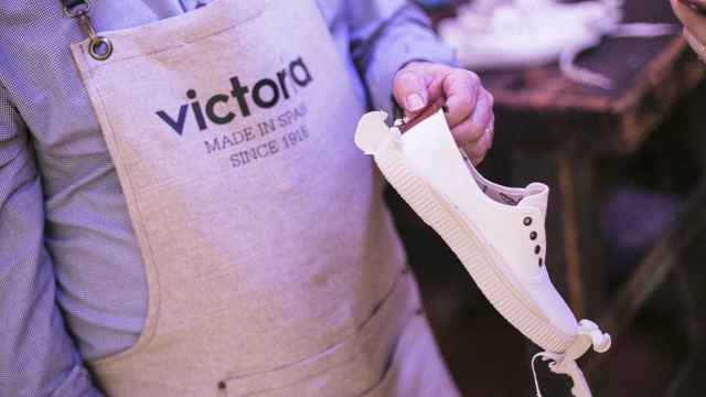 Un artesano muestra cómo queda una zapatilla de Victoria tras el proceso de vulcanizado.