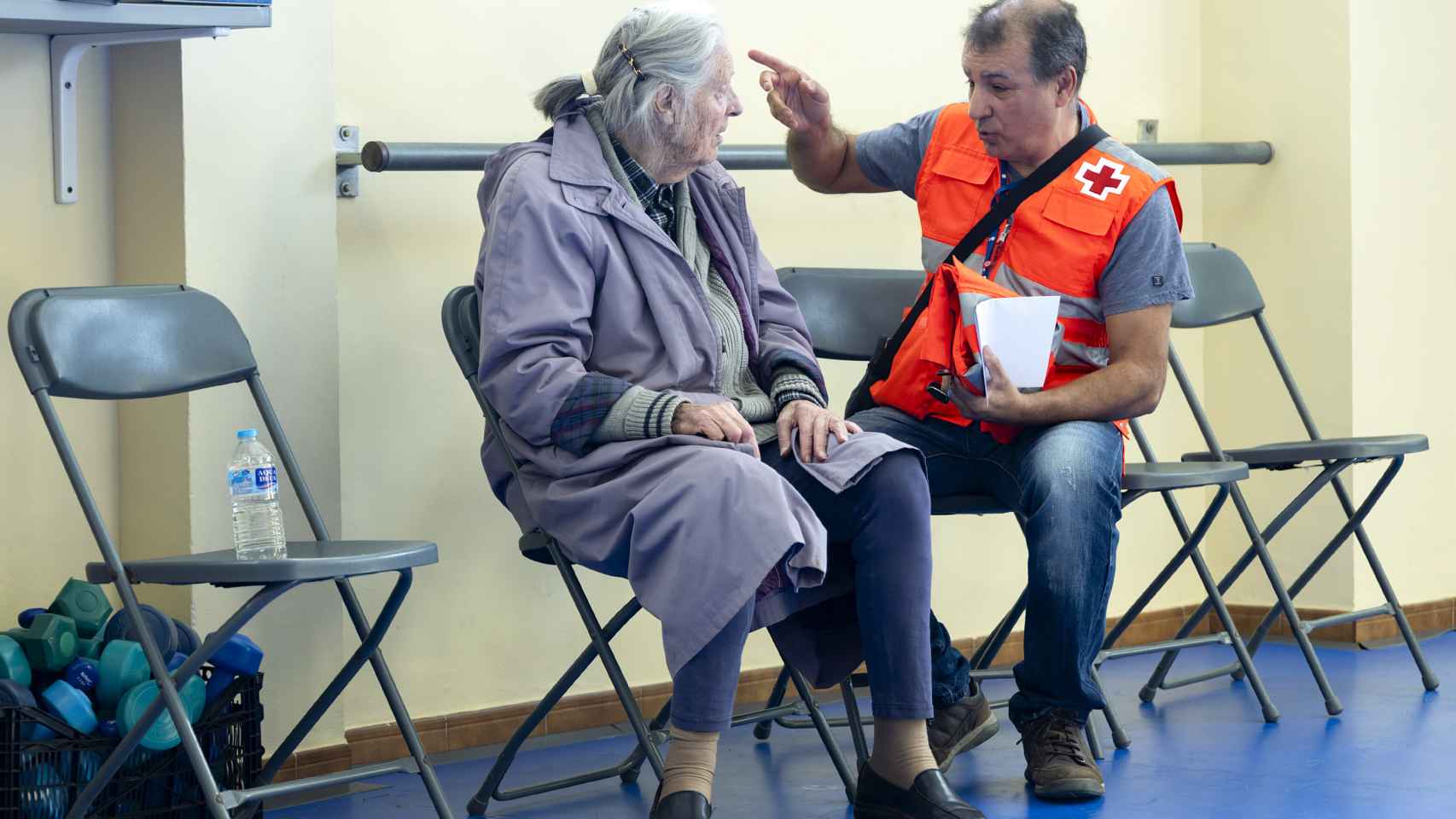 Una mujer evacuada habla con un colaborador de Cruz Roja.