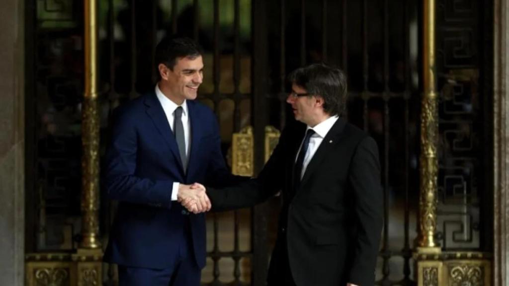 Pedro Sánchez y Carles Puigdemont dándose un apretón de manos