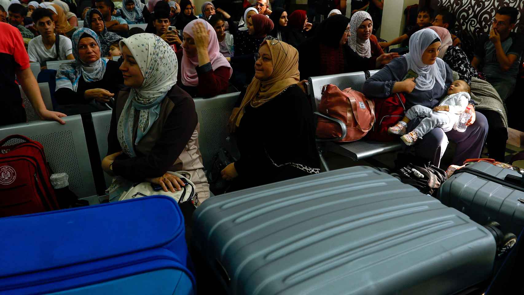 Palestinos con pasaporte extranjero esperan su turno para salir de Gaza.
