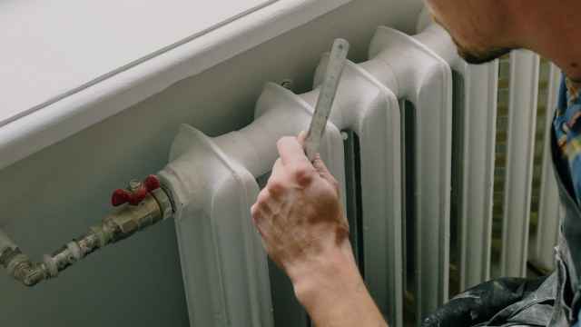 Imagen de un hombre ajustando un radiador