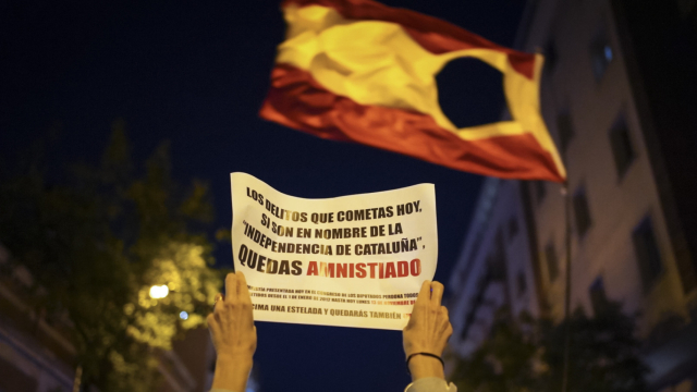 Una bandera española con el escudo agujereado durante las manifestaciones de Ferraz este lunes.
