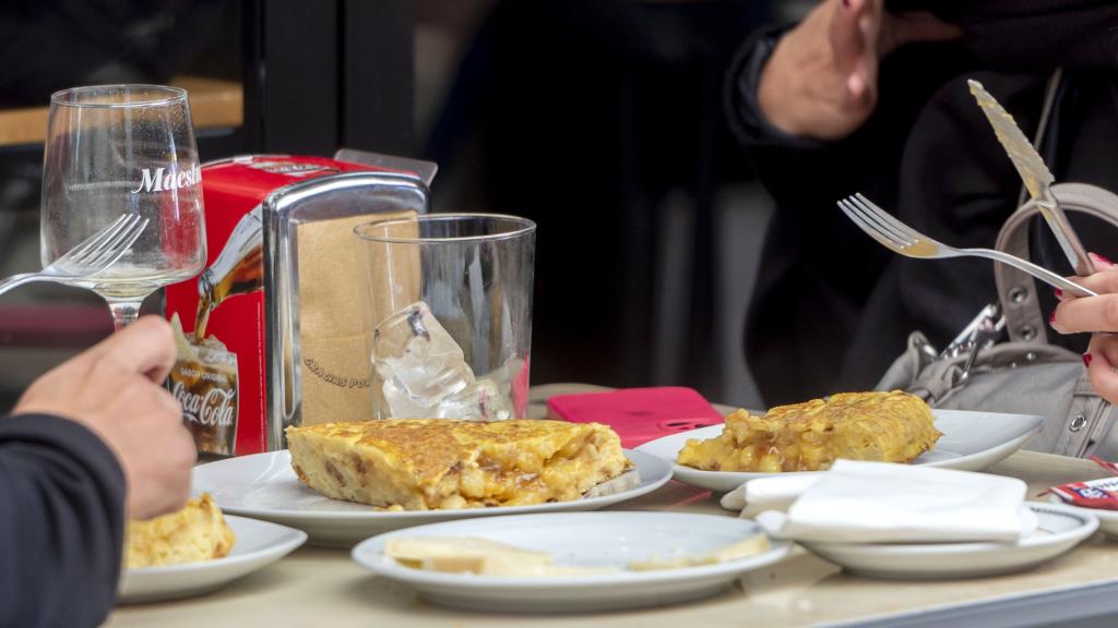 Varias personas comen una tortilla.