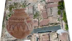 Imagen aérea de viviendas en el yacimiento de La Alcudia y una urna funeraria.