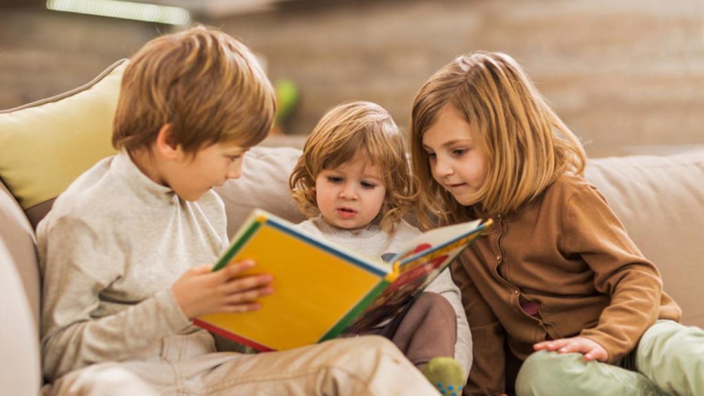 Niños leyendo en un sofá.