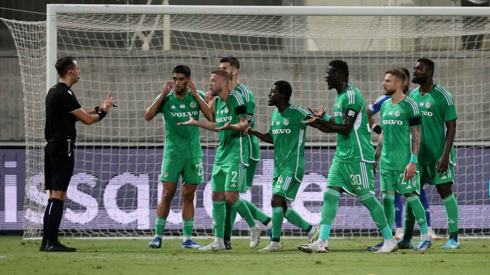 Los jugadores del Maccabi Haifa protestan una acción al árbitro durante su partido frente al Villarreal en la Europa League.