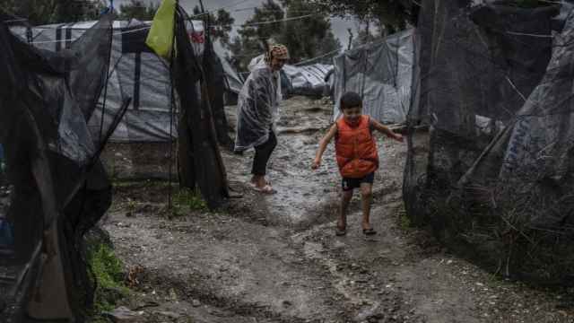 Un niño juega junto a su madre en el campo de refugiados de Moria.