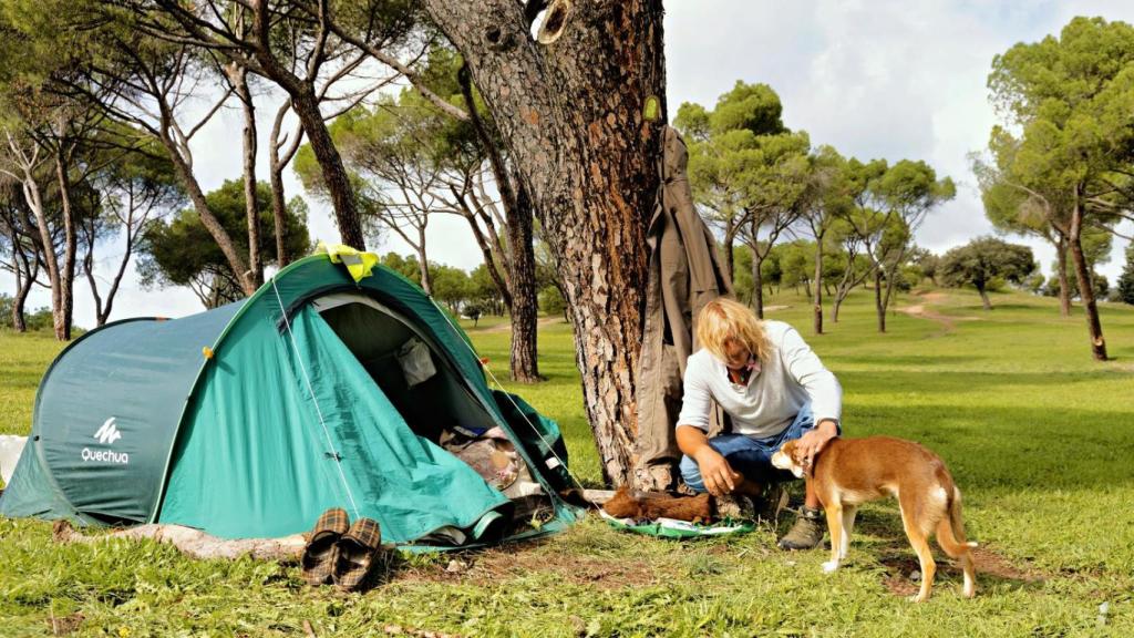 Rubén con uno de los perros que utiliza para el pastoreo y junto a su tienda de campaña en un monte