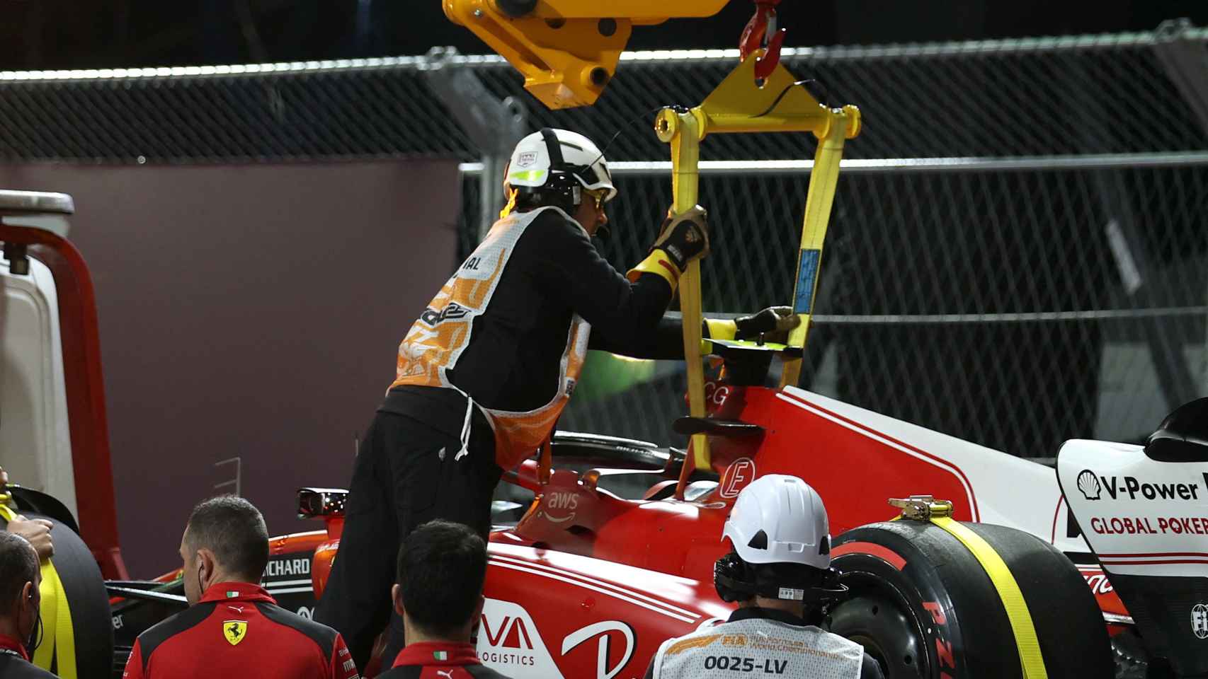 El Ferrari de Carlos Sainz siendo retirado tras el incidente con la alcantarilla.