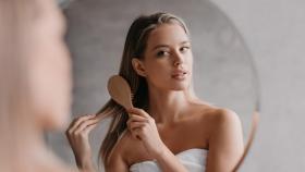 Mujer peinándose el cabello.