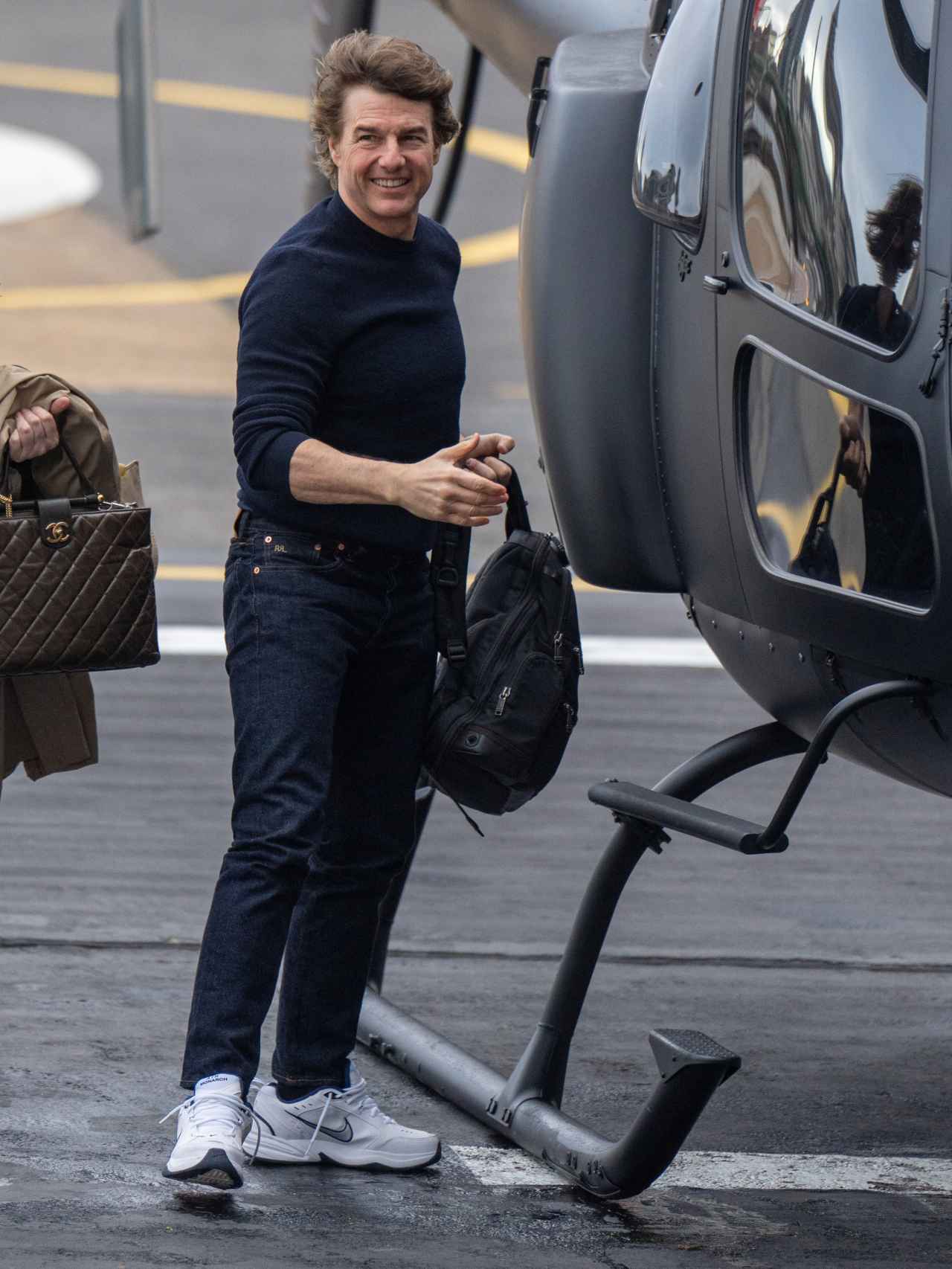 Tom Cruise luciendo un estilismo juvenil previo a montarse en el helicóptero.