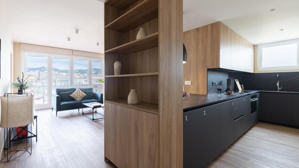 Imagen de un salón y de la cocina en uno de los 'coliving' de Cotown.