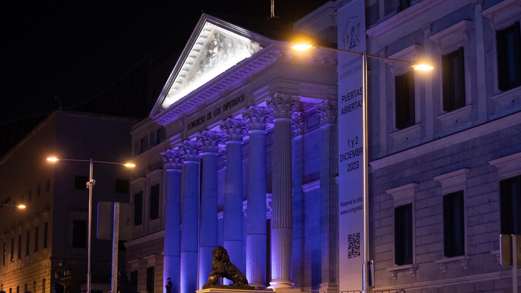 La fachada del Congreso de los Diputados iluminada de color morado, este sábado.