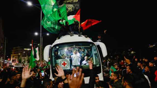 Los presos palestinos liberados llegan en autobús a la ciudad de Ofer, donde miles de personas celebran su salida.