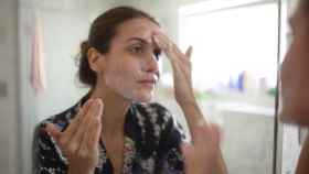 Imagen de una mujer limpiándose la cara con jabón.