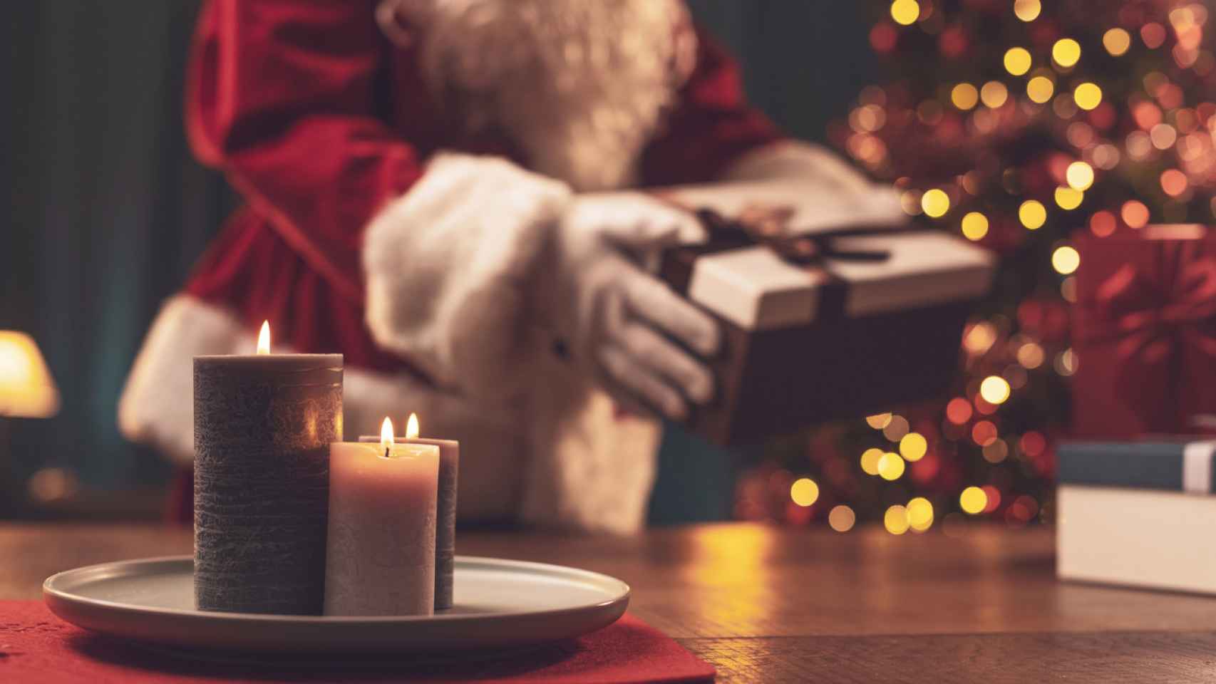 Unas velas aromatizan una casa donde Santa Claus está dejando regalos. iStock