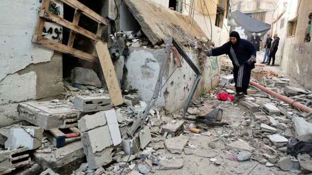 Una mujer avanza entre los escombros en Gaza