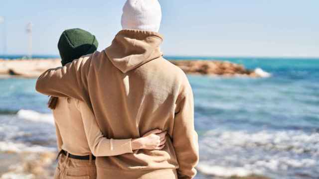 Imagen de una pareja abrazándose a la orilla del mar