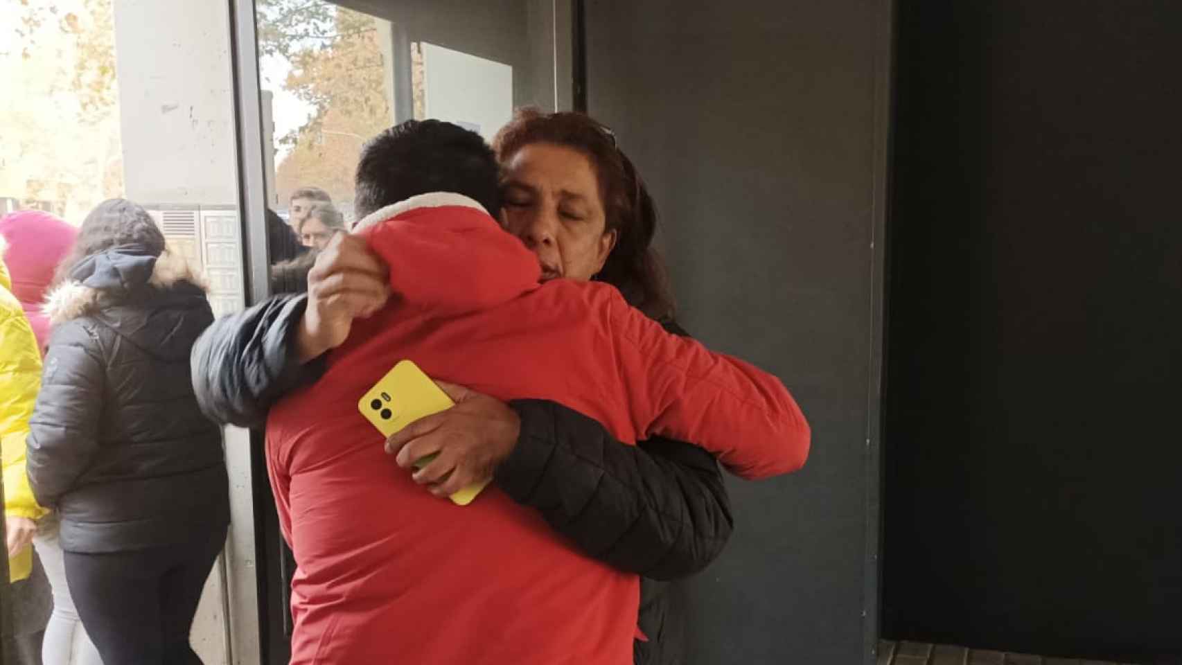 Una vecina abraza al padre de Tatiana en el bloque de pisos donde fue asesinada.