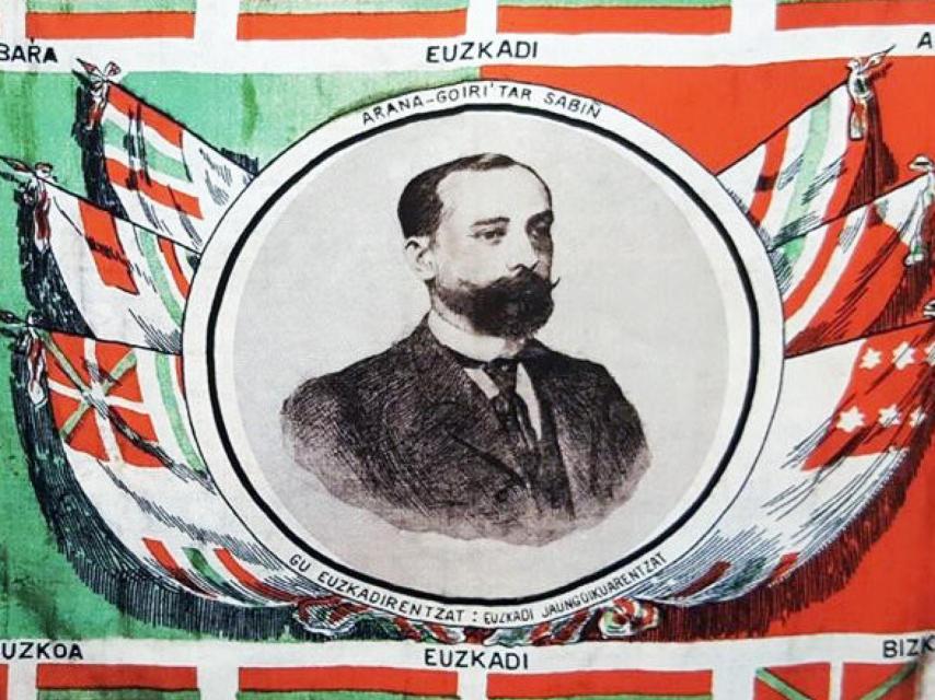 La ikurriña inventada por Sabino Arana Goiri y representada en un pañuelo diseñado por Luis Arana, con la efigie de Sabino Arana.