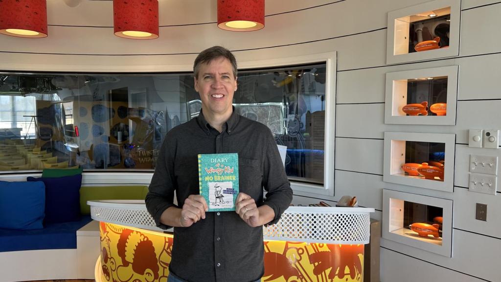 Jeff Kinney sostiene un ejemplar de su libro 'Diario de Greg, 18: Descerebrados', en su versión inglesa.