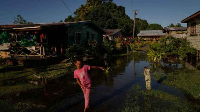 Una niña de 10 años vadea el agua de mar que inunda su comunidad durante la marea alta en el pueblo de Fiyi, 15 de julio de 2022.