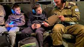 Dos hermanos, con un soldado israelí, después de ser liberados por Hamás en el cuarto día de tregua
