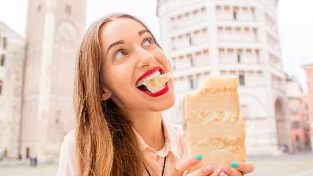 Una mujer comiendo un gran trozo de queso a bocados