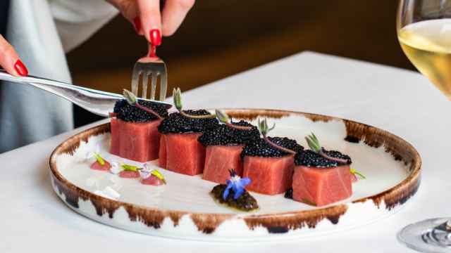 Imagen de una mujer comiendo atún rojo en un restaurante