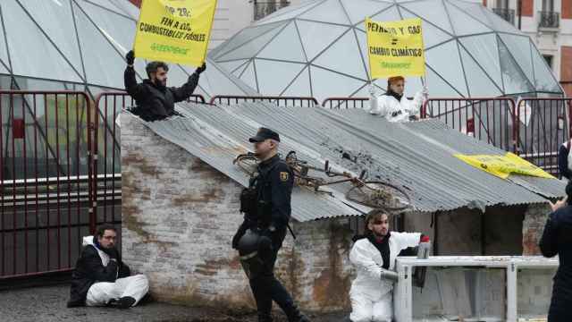 Activistas de Greenpeace han esparcido este miércoles en la madrileña Puerta del Sol restos de enseres y otros objetos destruidos.