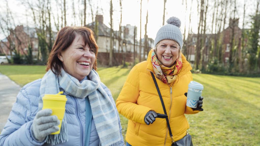 Imagen de dos mujeres paseando mientras toman un café