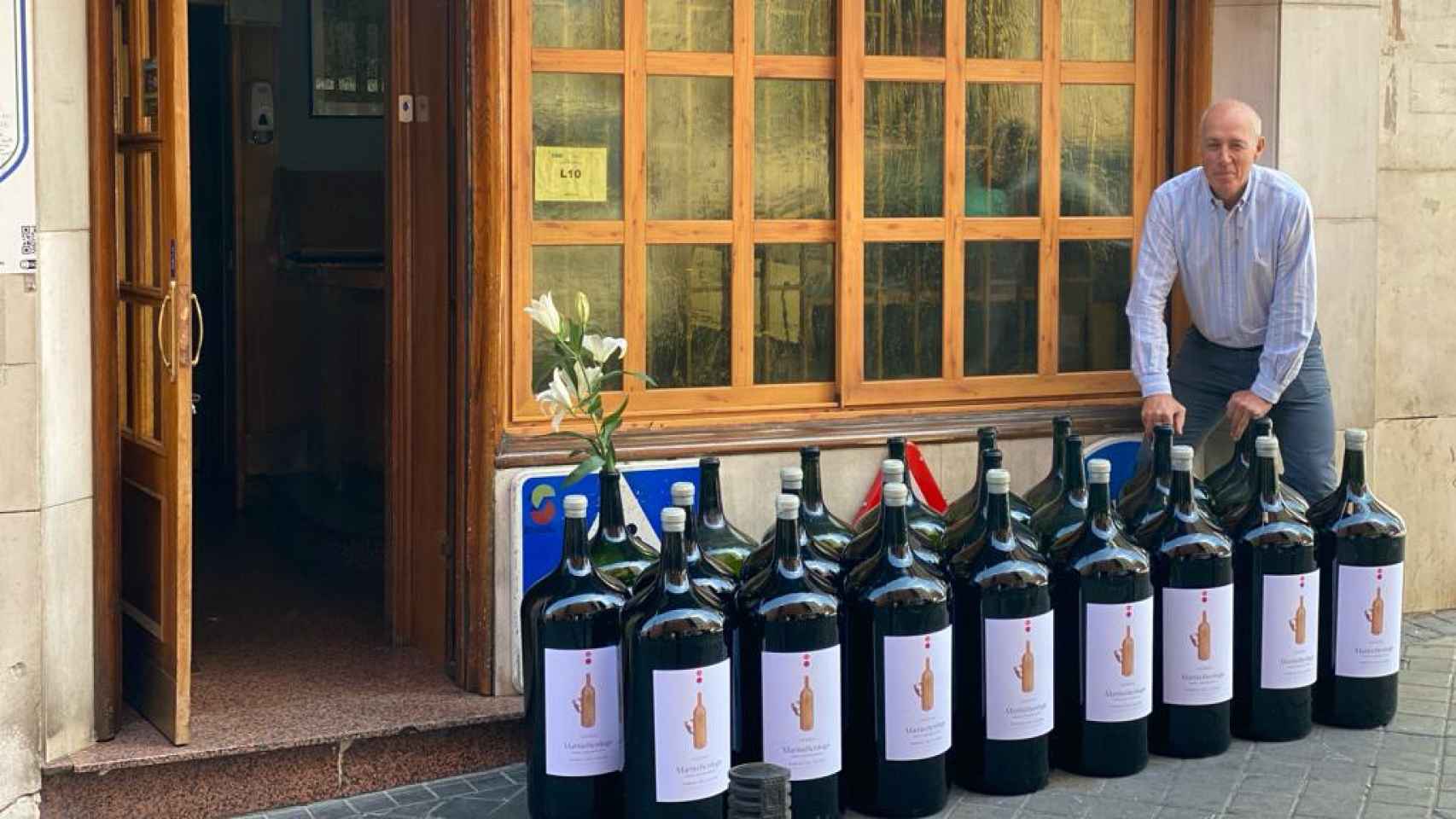 Pepe Morán con las botellas de vino de 27 litros en la entrada del restaurante.