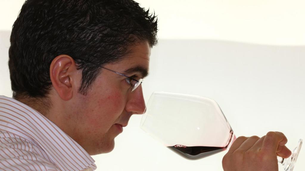 Julio Biosca, jefe de sala, huele una copa de vino.