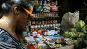 Una mujer pasa junto a un puesto que vende medicinas en la ciudad de Rubio, fronteriza con Colombia.