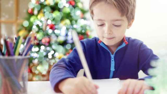 Imagen de un niño dibujando una postal de Navidad.