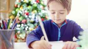 Imagen de un niño dibujando una postal de Navidad.