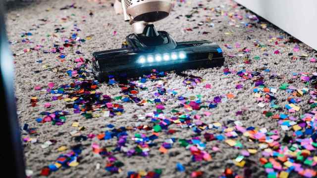 Imagen de una aspiradora limpiando una alfombra con confeti