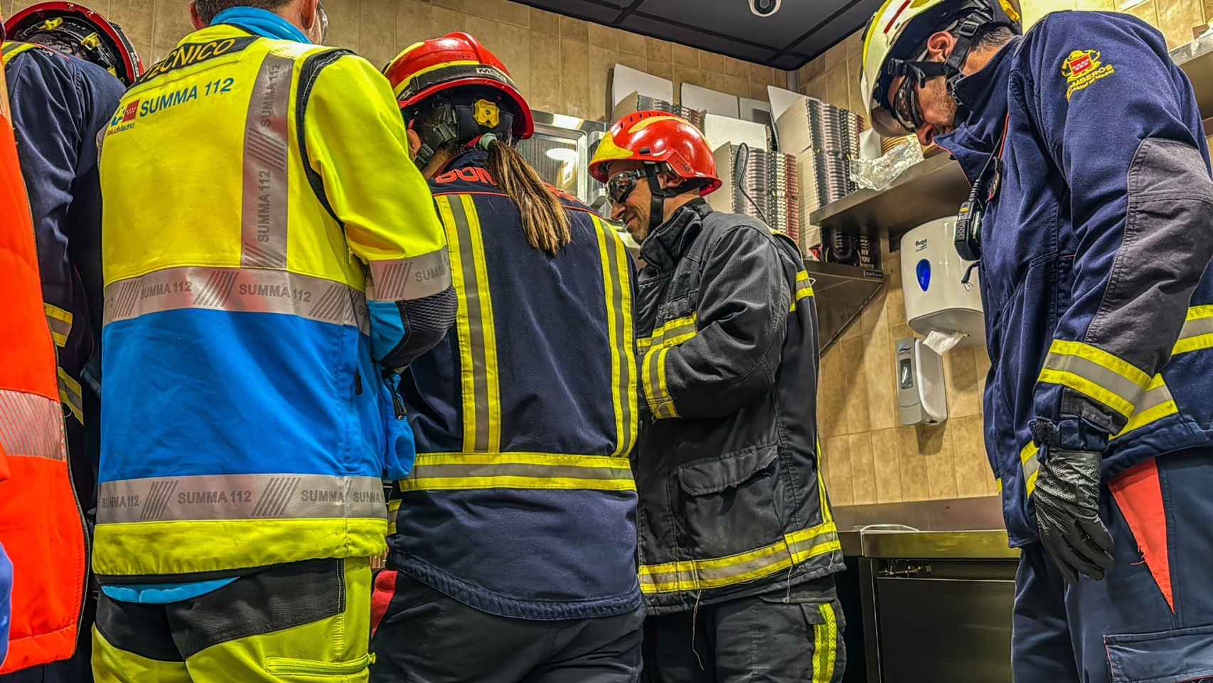 Los bomberos tratando de rescatar la mano del trabajador atrapada en un restaurante.