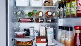 Una mujer duda al colocar los alimentos en el frigorífico.