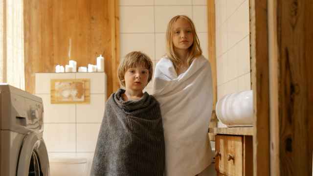 Imagen de dos niños enrollados con toallas en el baño